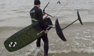 kitesurfer loopt in het water met een hydrofoil